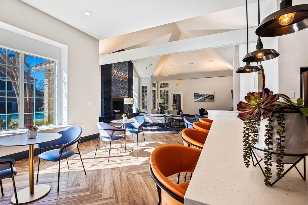 a dining room with tables and chairs and a large window at The Olivine, Austin